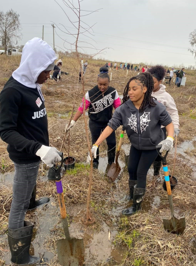 Group of teenagers digging ground to plant trees