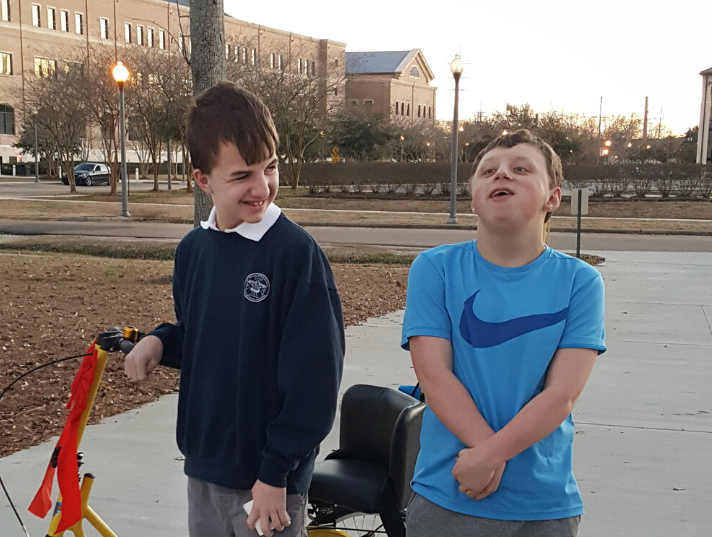 two special needs young boys hanging out with a bike