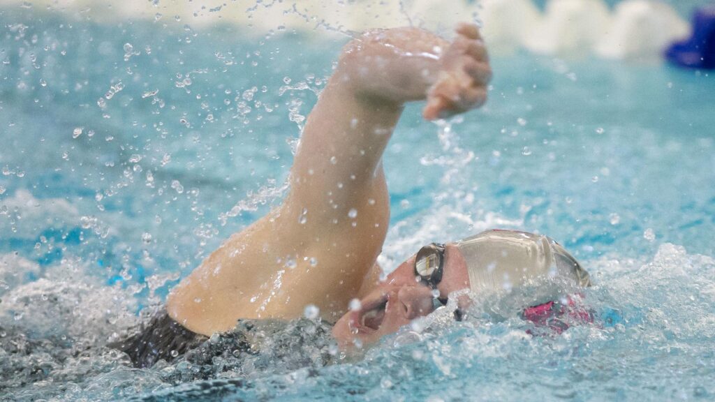 Person swimming competitively in pool